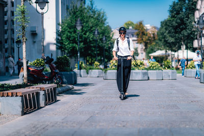 Man standing on footpath in city