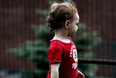 Side view of cute baby girl looking away while standing outdoors