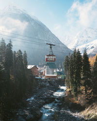 Buildings by mountain against sky during winter