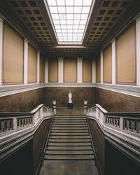 Rear view of person standing on staircase in building