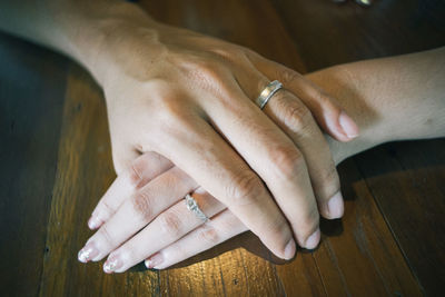 Close-up of couple holding hands on table