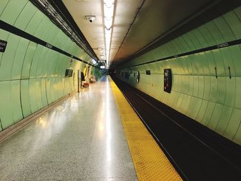 Empty platform at illuminated subway station
