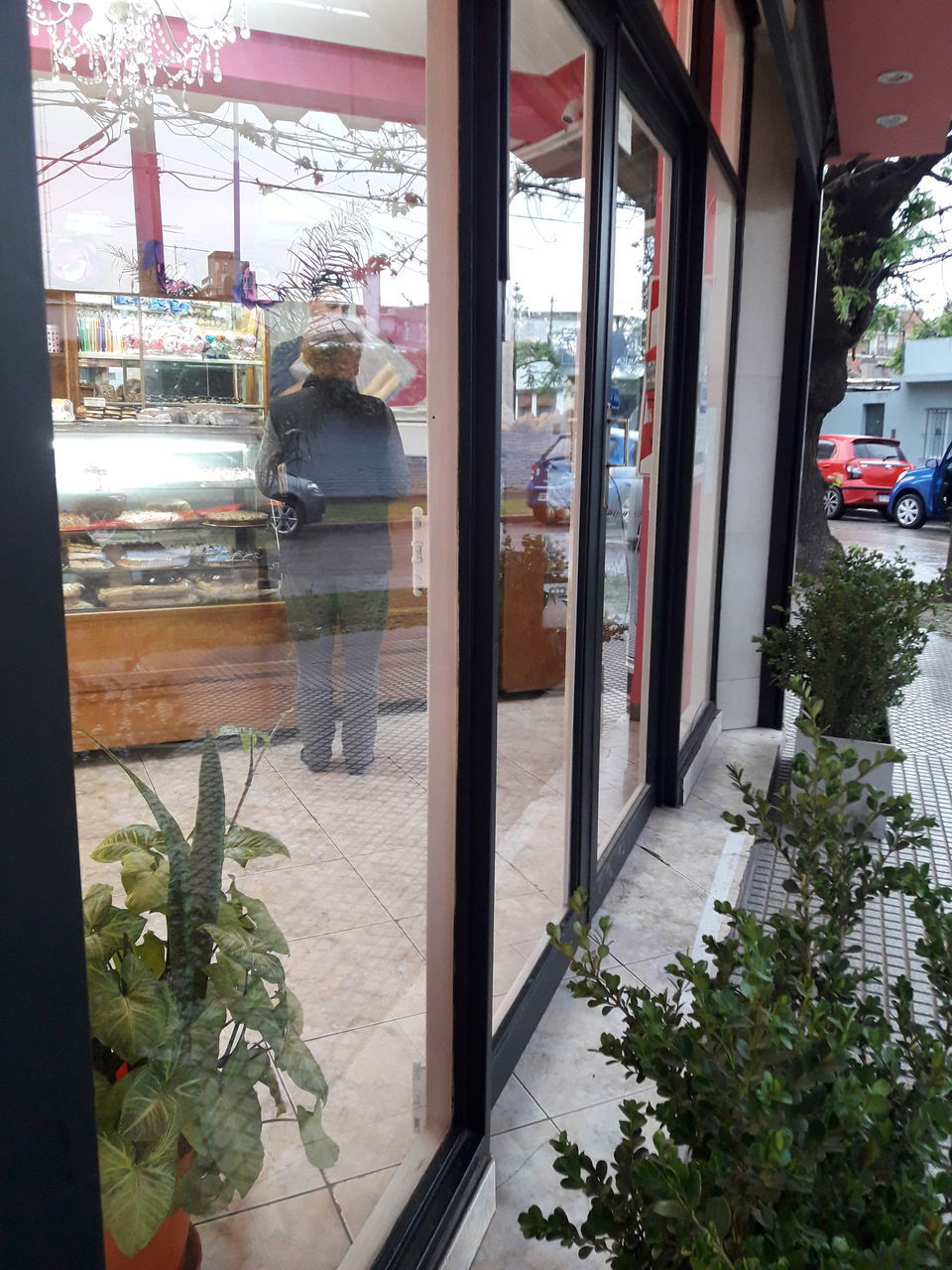 REFLECTION OF MAN IN GLASS WINDOW