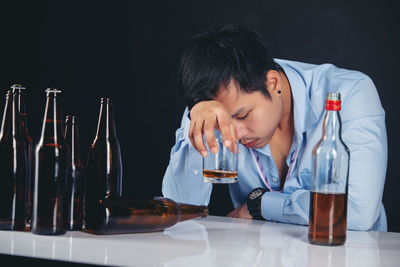 Young man drinking glasses on table