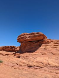 Rock formations in desert against clear blue sky