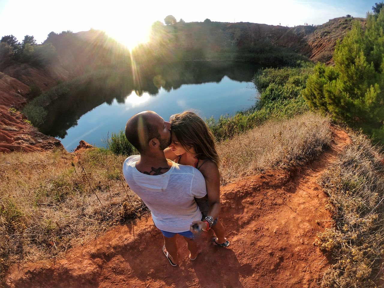 REAR VIEW OF FRIENDS ON ROCK