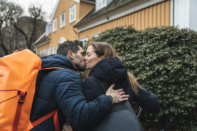 Happy couple kissing each other at back yard