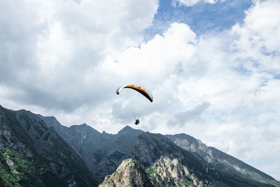 Low angle view of person paragliding against sky