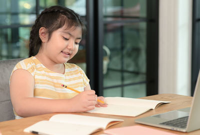 Close-up of girl studying at table