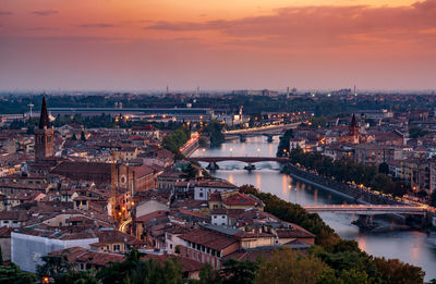 High angle view of river amidst buildings against sky during sunset