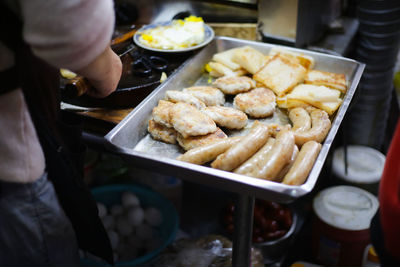 Close-up of man preparing food in tray