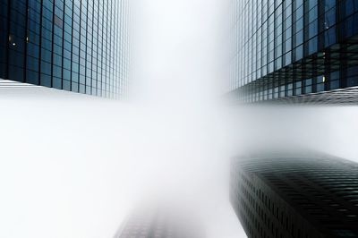 Low angle view of skyscrapers in foggy weather