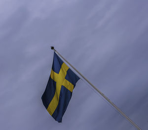 Low angle view of flag against blue sky
