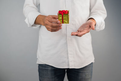 Midsection of man holding ice cream against white background