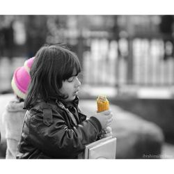 Portrait of girl holding bottle in city