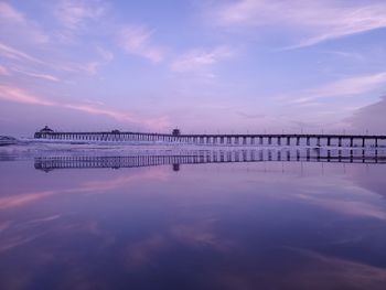 Pier over sea against sky during sunset