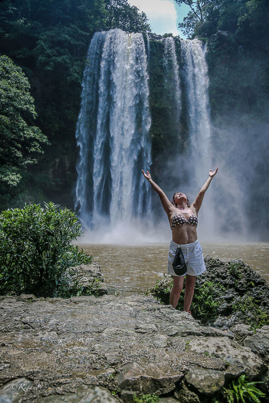 FULL LENGTH OF YOUNG WOMAN STANDING ON ROCK