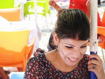 Close-up of smiling woman sitting outdoors