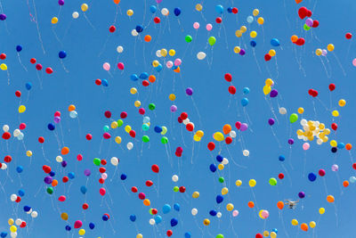 Low angle view of balloons against blue sky