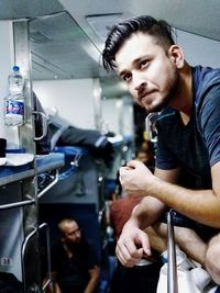 Portrait of young man standing in bus