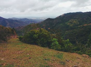 Scenic view of mountains against cloudy sky