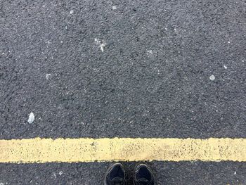 Low section of person standing on road