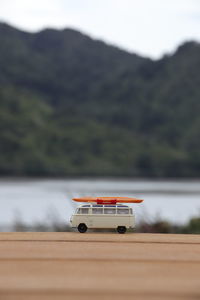 Close-up of toy car on table by lake