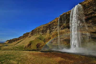 Scenic view of waterfall against sky