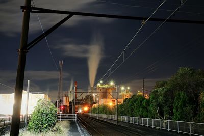 Train on railroad tracks against sky at night