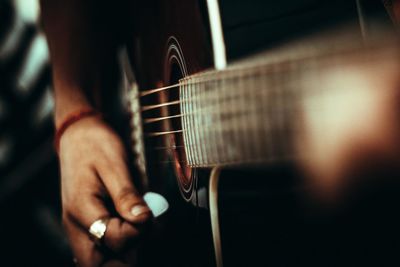 Close-up of cropped hand playing guitar