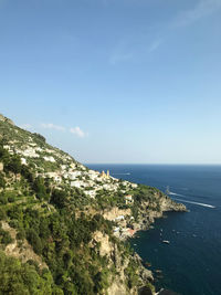 High angle view of sea and mountains against blue sky