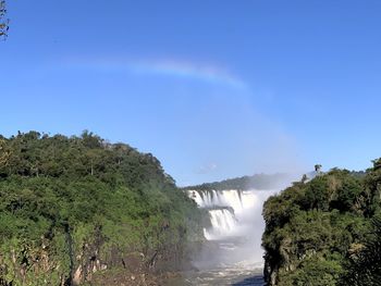 Scenic view of waterfall against sky