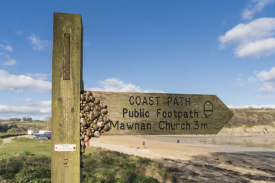 Close-up of text on beach against sky