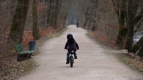 Bicycling on pathway along trees