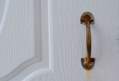 Close-up of door knocker on white wall