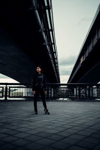 Full length of man on bridge against sky in city