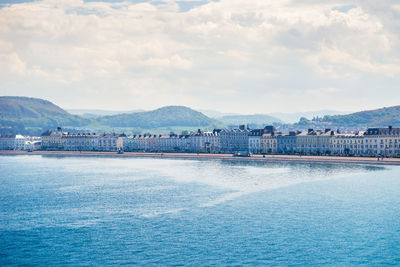 Scenic view of sea by city against sky