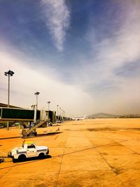 Vehicle on airport runway against sky