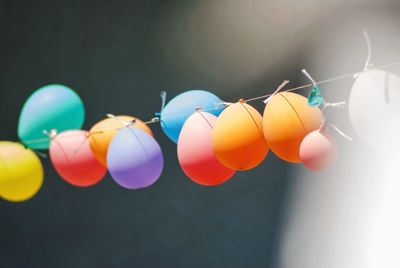 Group of colorful balloons chained together on wire outdoor.