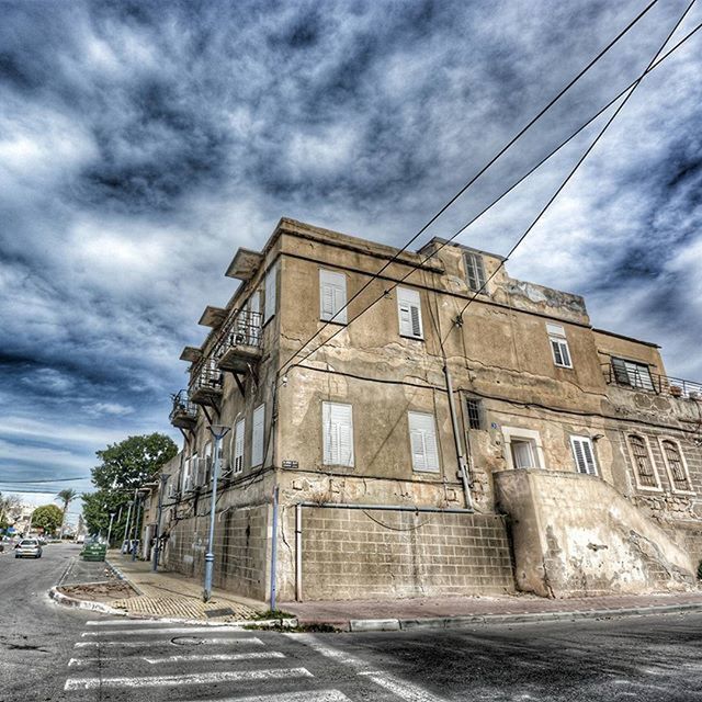 sky, cloud - sky, architecture, built structure, cloudy, building exterior, the way forward, transportation, road, street, cloud, diminishing perspective, overcast, weather, car, storm cloud, vanishing point, low angle view, outdoors, day