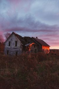 Abandoned house on landscape against sky