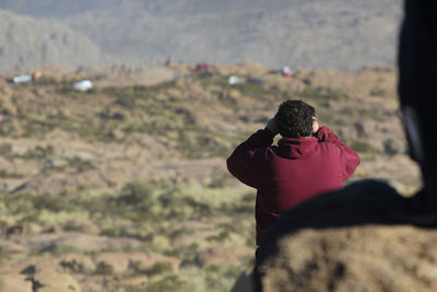 Rear view of man photographing outdoors