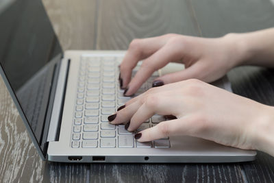 Midsection of man using mobile phone on table