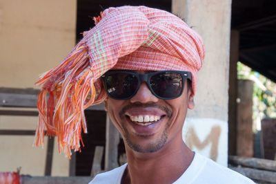 Portrait of smiling man wearing sunglasses and headscarf 