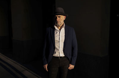 Portrait of adult man in suit with hat on street during sunset. madrid, spain