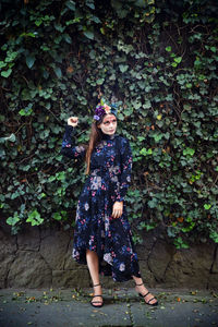 Full length portrait of girl standing against plants