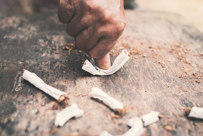 Cropped image of hand crushing cigarette