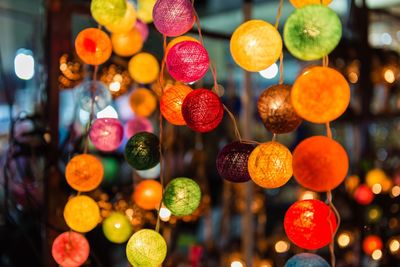 Close-up of illuminated multi colored lighting equipment hanging at night