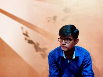 Portrait of young man against wall at home