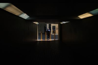 People in illuminated corridor